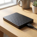 Black portable external hard drive with geometric textured top and USB cable