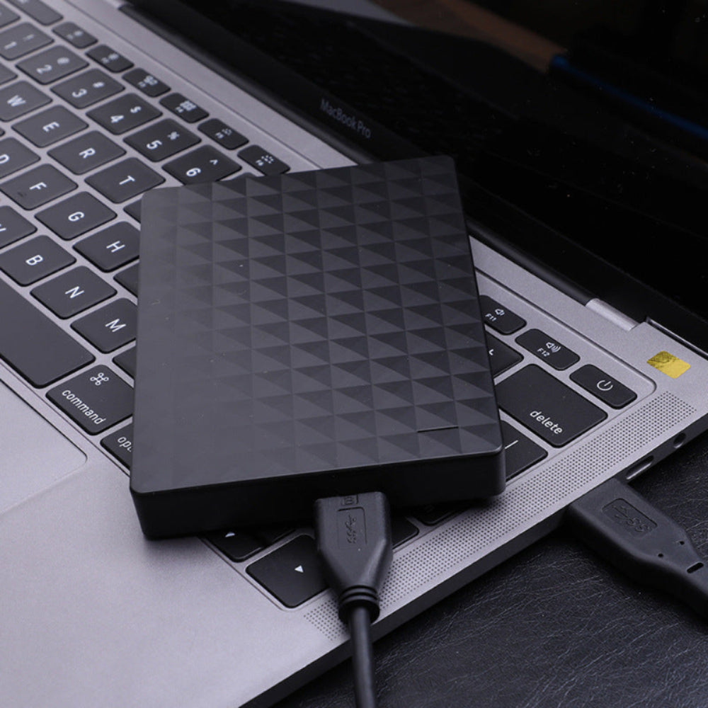 Black portable external hard drive with geometric textured top and USB cable
