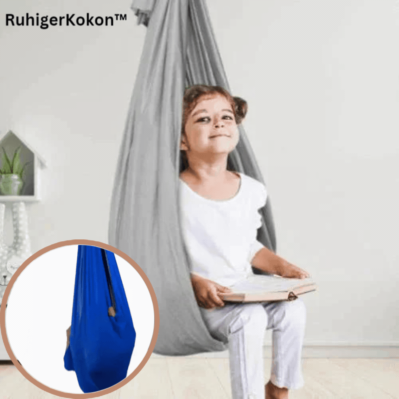 Child sitting in a fabric indoor hanging pod swing