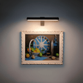 Cordless rotatable LED picture light mounted above framed artwork