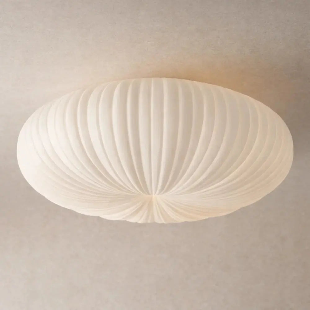White sculpted flush ceiling light with a pleated rounded shade