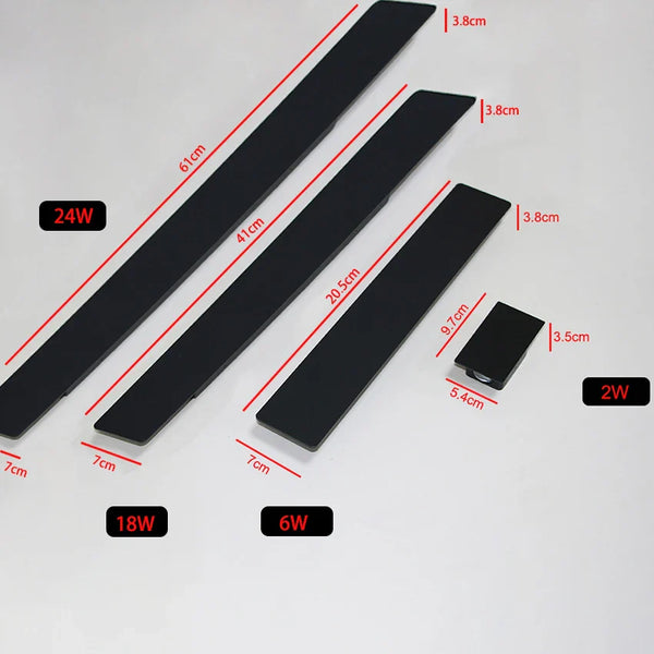 Black vertical outdoor LED wall light casting warm white light upward and downward