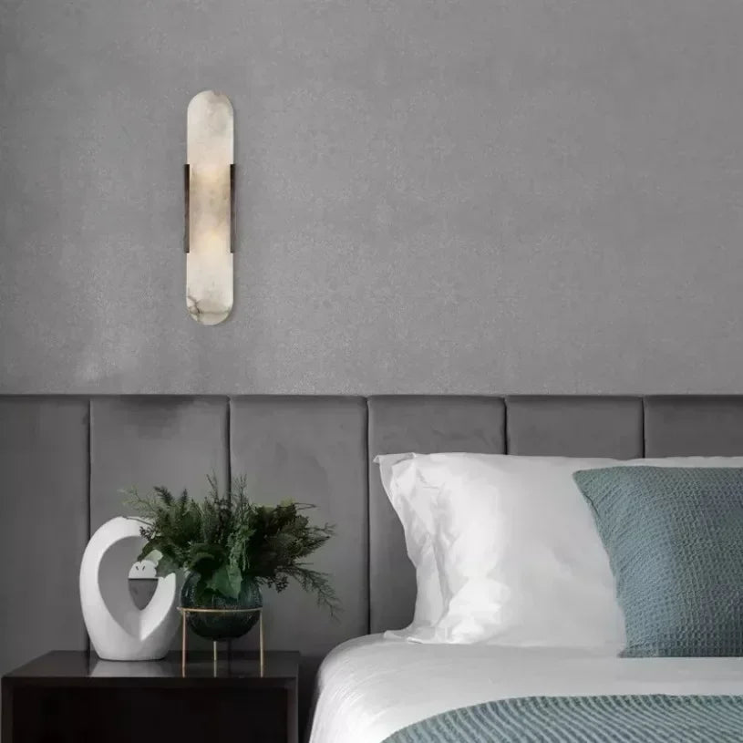 Vertical LED wall sconce with a light marble panel and contrasting side rails
