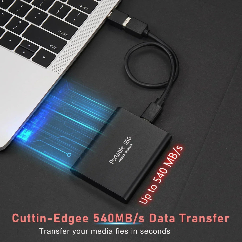 Portable SSD external drive with USB cable beside a laptop