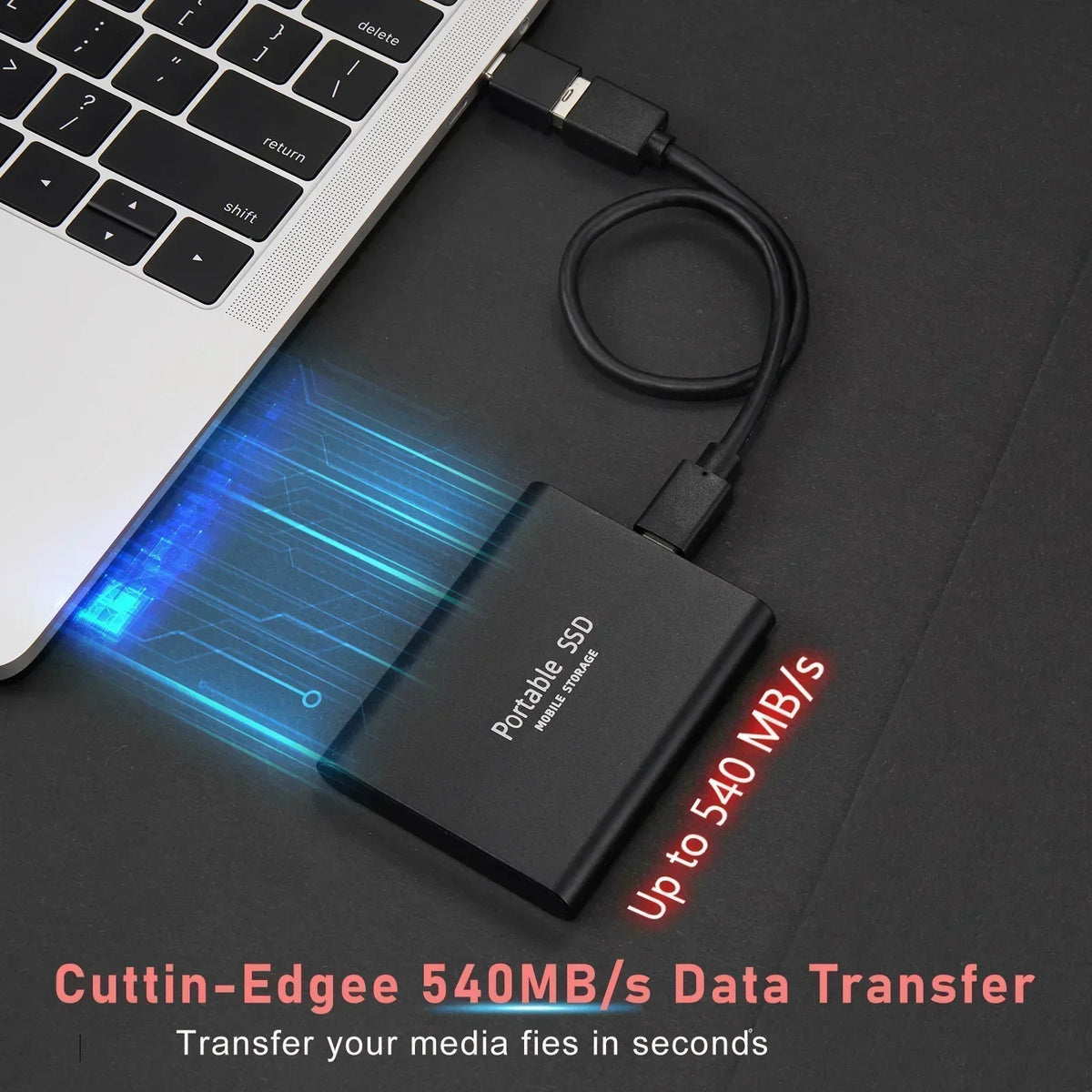 Portable SSD external drive with USB cable beside a laptop