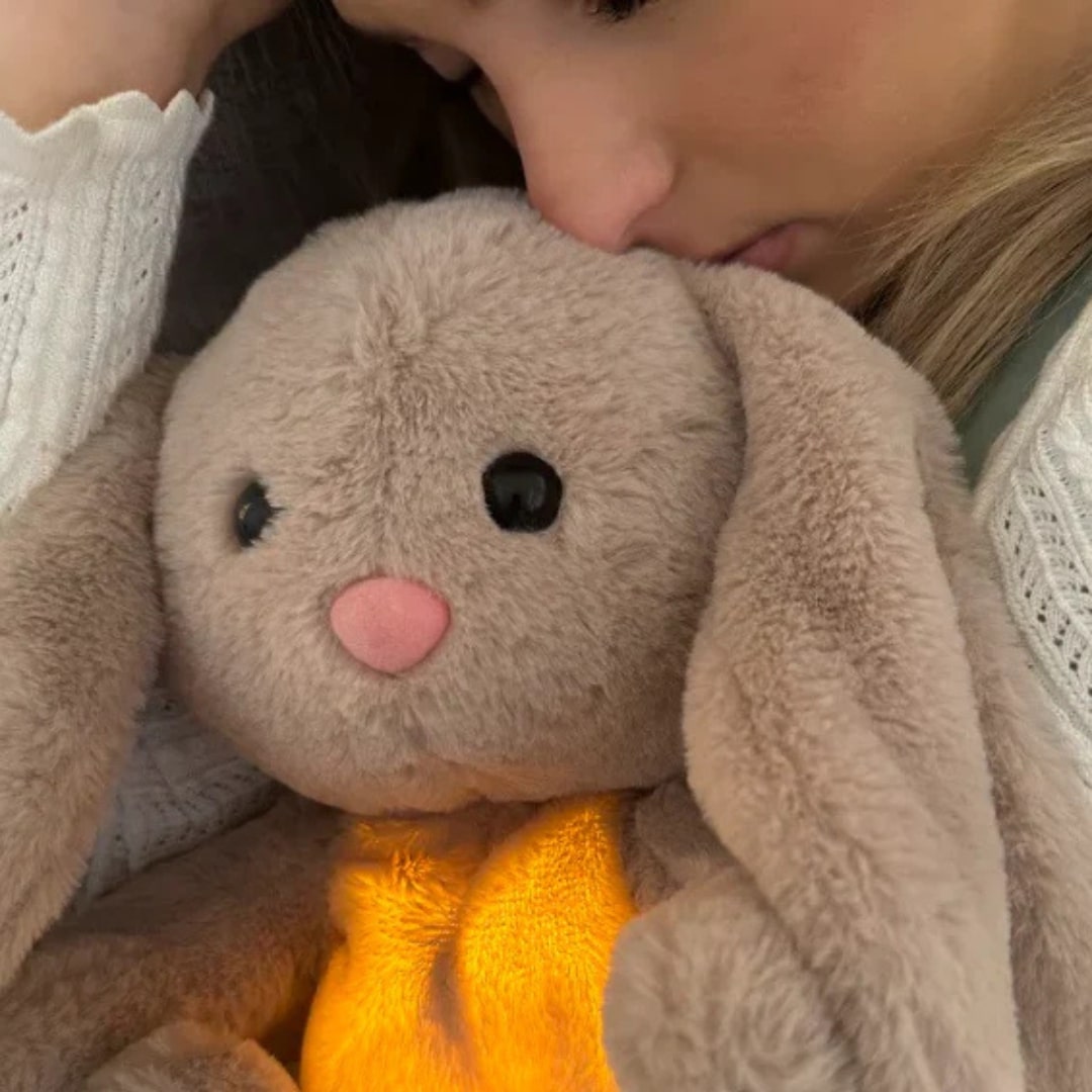 Gray bunny stuffed animal with long ears and glowing yellow belly