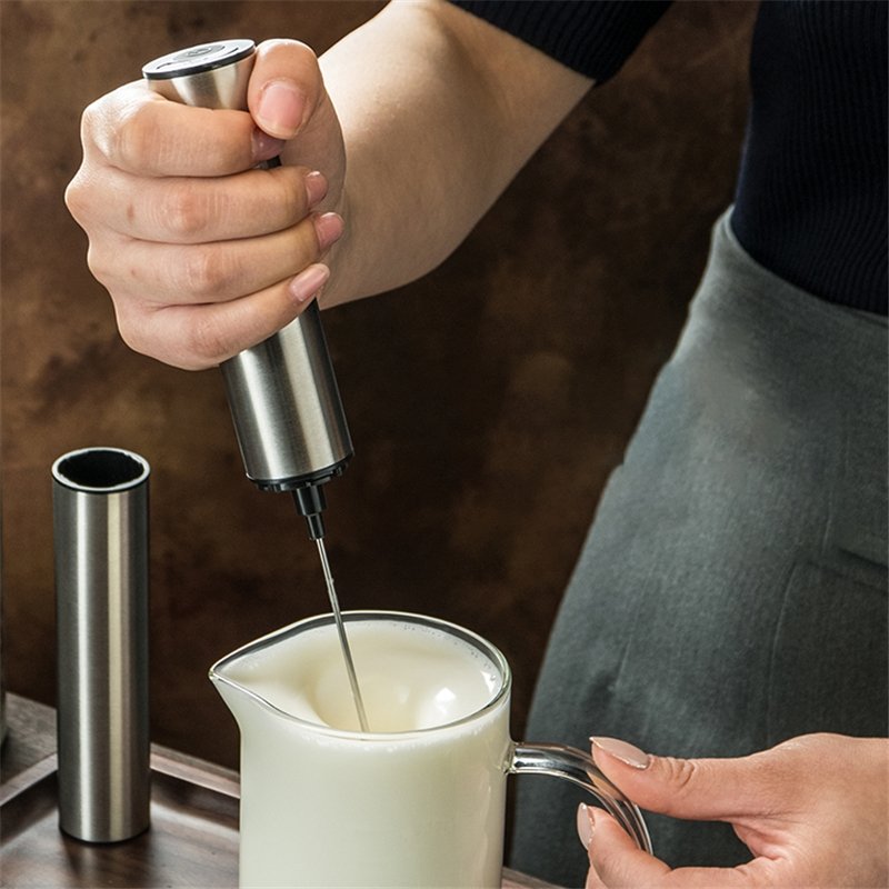 Silver cordless handheld milk frother with whisk head and storage sleeve