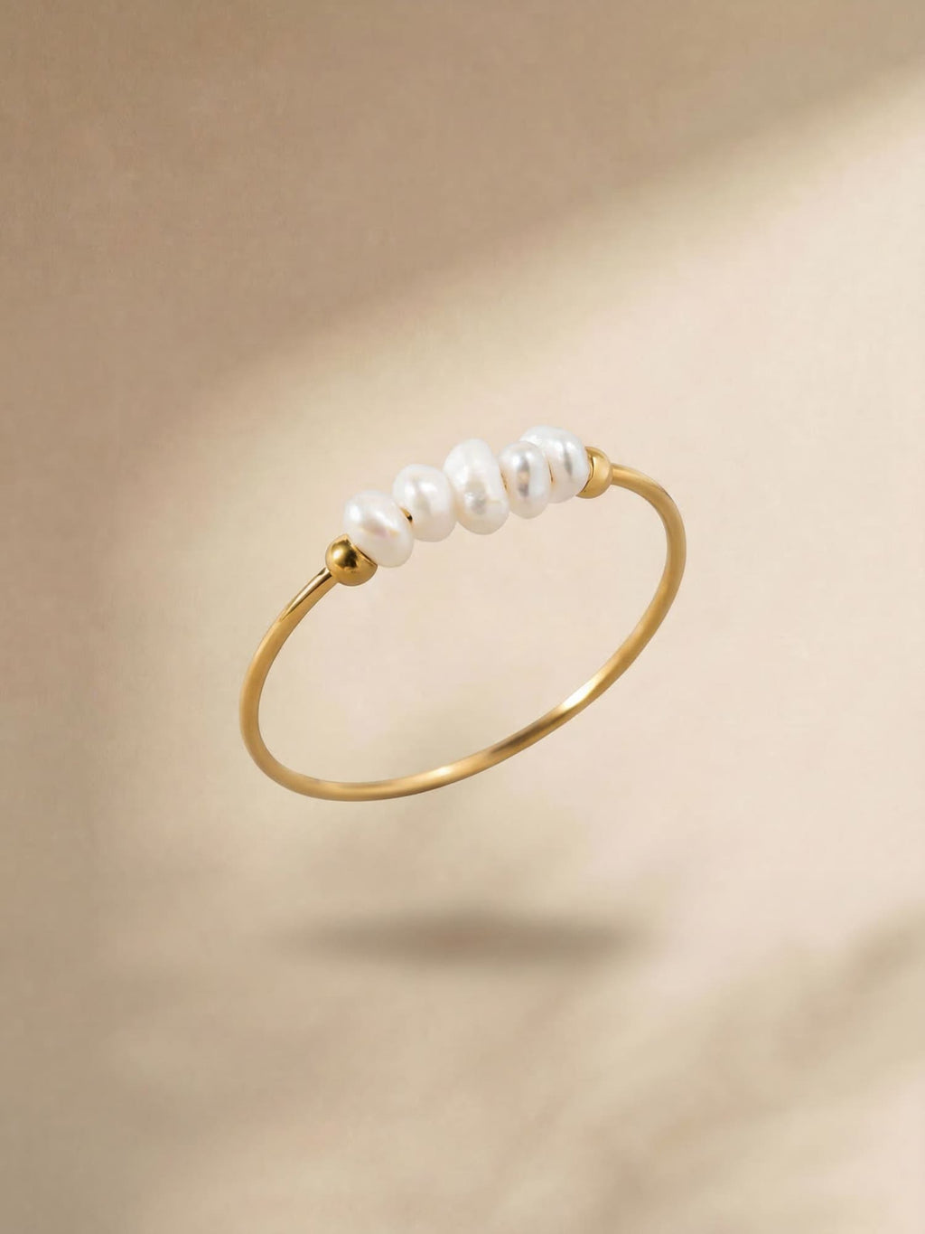 Gold-tone ring with a row of white pearl details