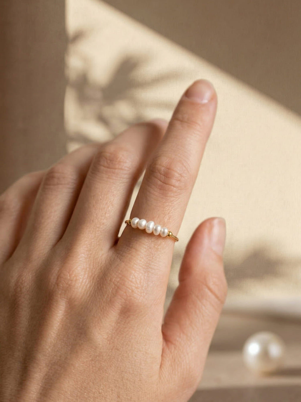 Gold-tone ring with a row of white pearl details