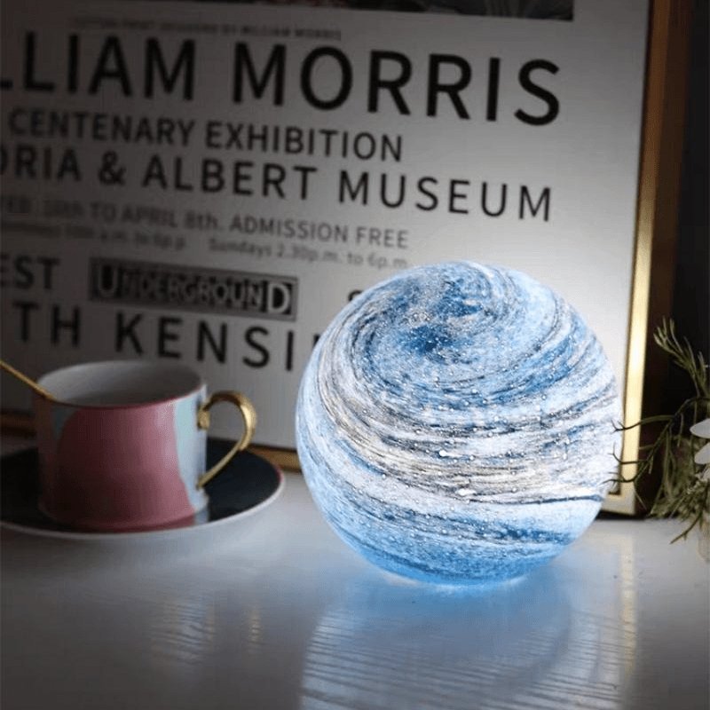 Spherical glass moon table lamp with swirling cosmic detailing