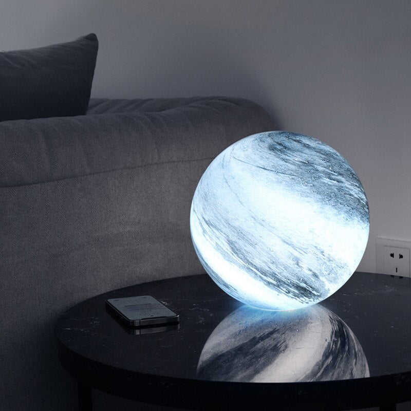Spherical glass moon table lamp with swirling cosmic detailing