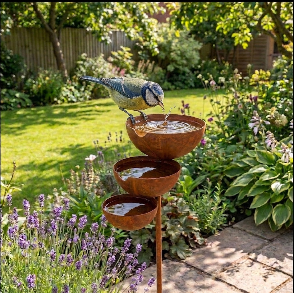 Vintage brown three-tier bird bath with three bowl basins on a garden stake