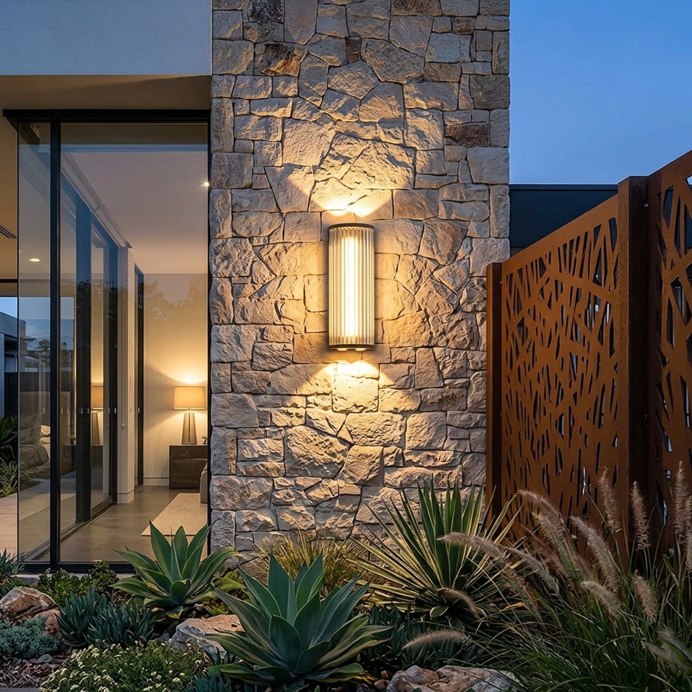 Black outdoor wall light with vertical glass shade and up and down illumination