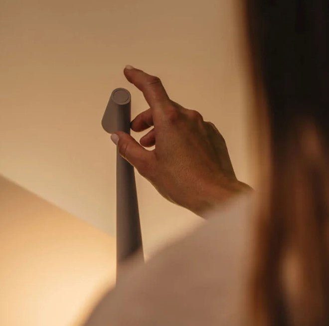 Cordless LED table lamp with a tall tapered body and angled light head