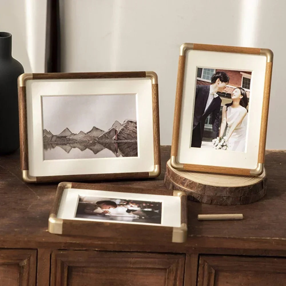 Tabletop photo frame with wood-effect border and brass-effect corner details