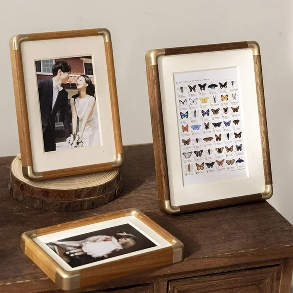Tabletop photo frame with wood-effect border and brass-effect corner details