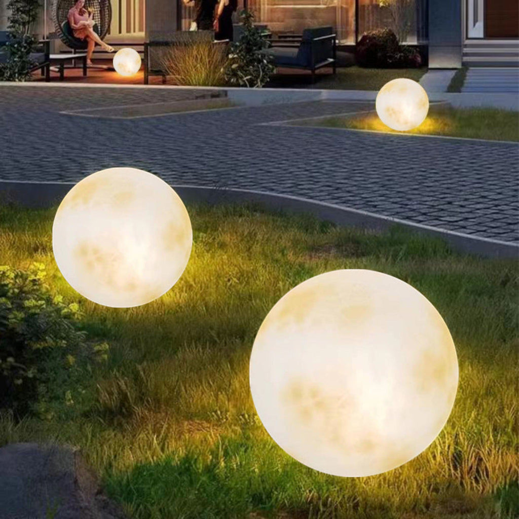 Illuminated yellow moon sphere garden lamp with mottled surface