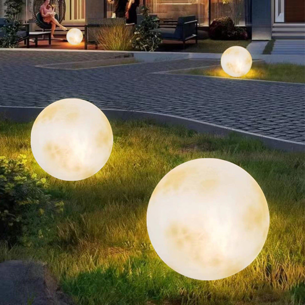 Illuminated yellow moon sphere garden lamp with mottled surface