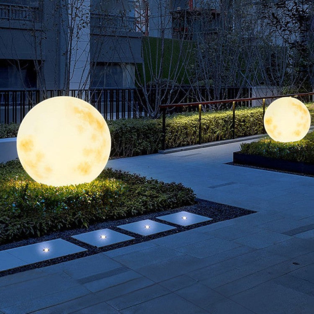 Illuminated yellow moon sphere garden lamp with mottled surface