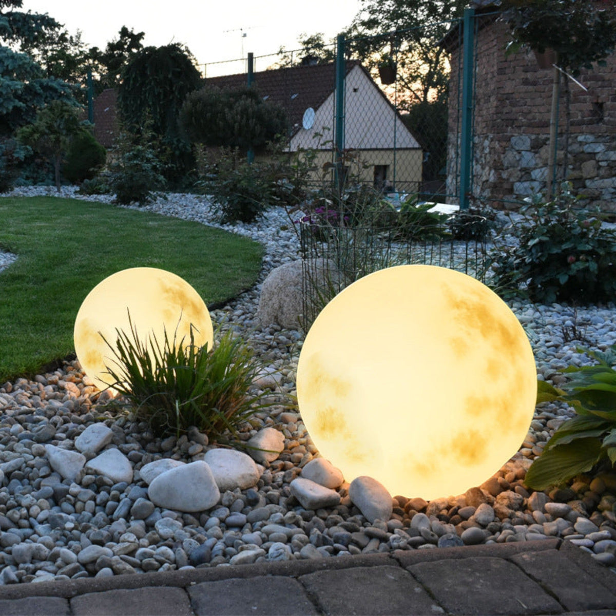 Illuminated yellow moon sphere garden lamp with mottled surface