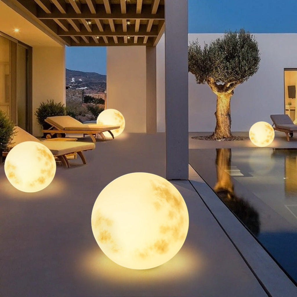 Illuminated yellow moon sphere garden lamp with mottled surface