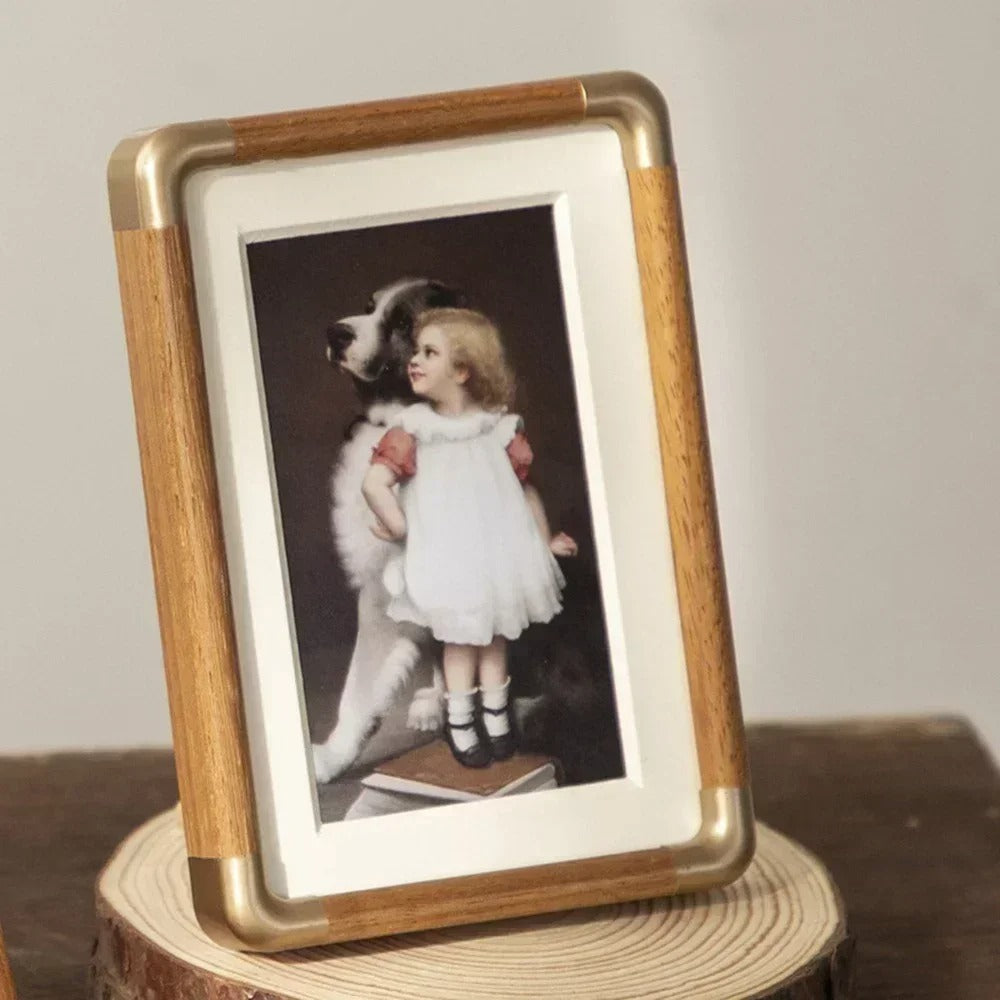 Tabletop photo frame with wood-effect border and brass-effect corner details